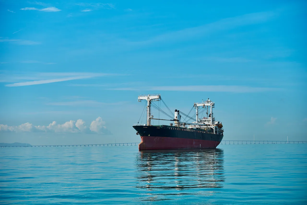 Cargo ship on a calm blue sea under a clear sky