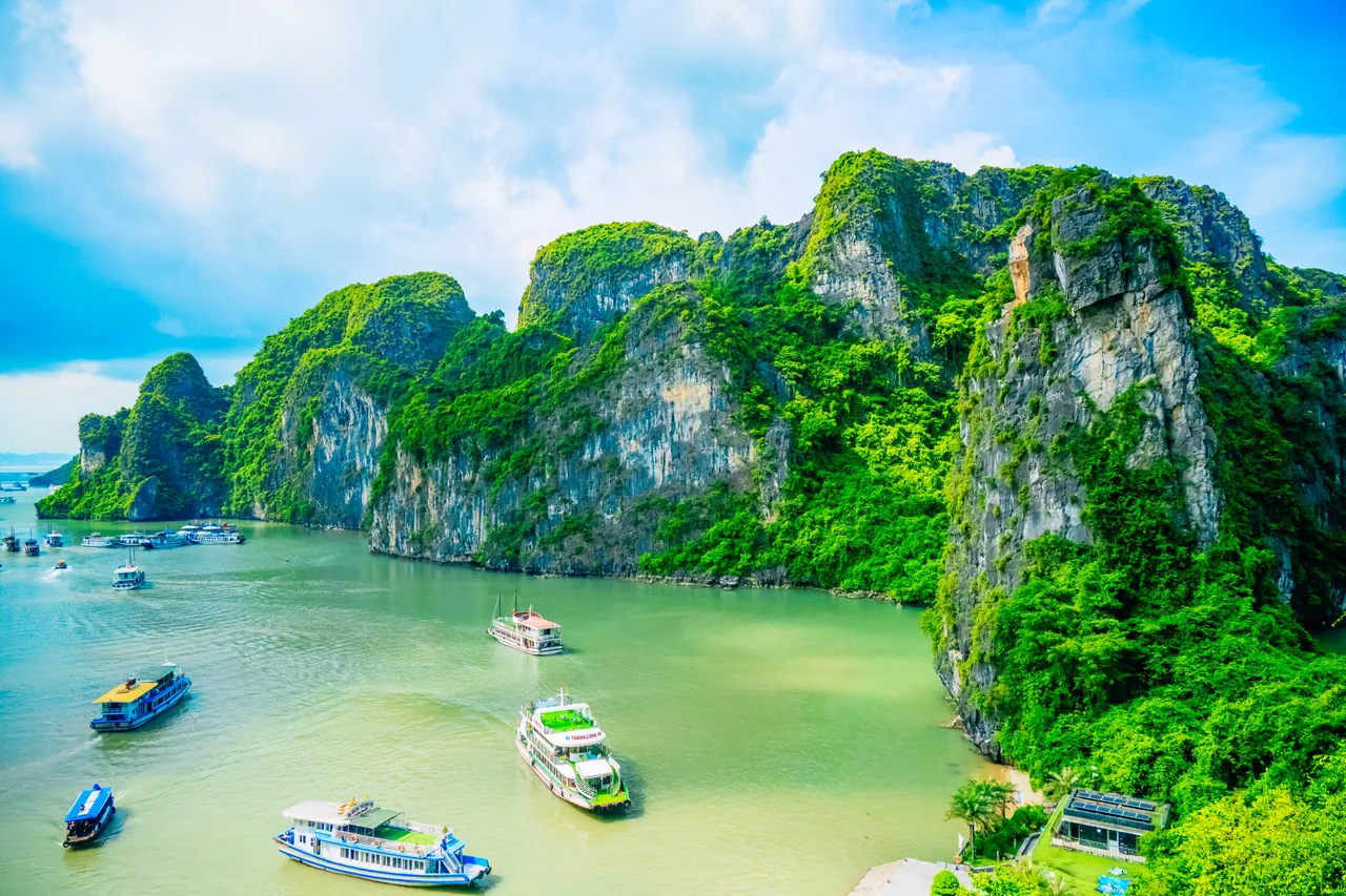 Boats moored in a bay surrounded by limestone karst cliffs