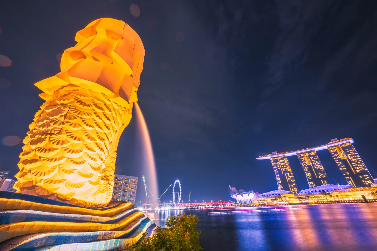 Close-up of the Merlion at night with Marina Bay Sands across the water