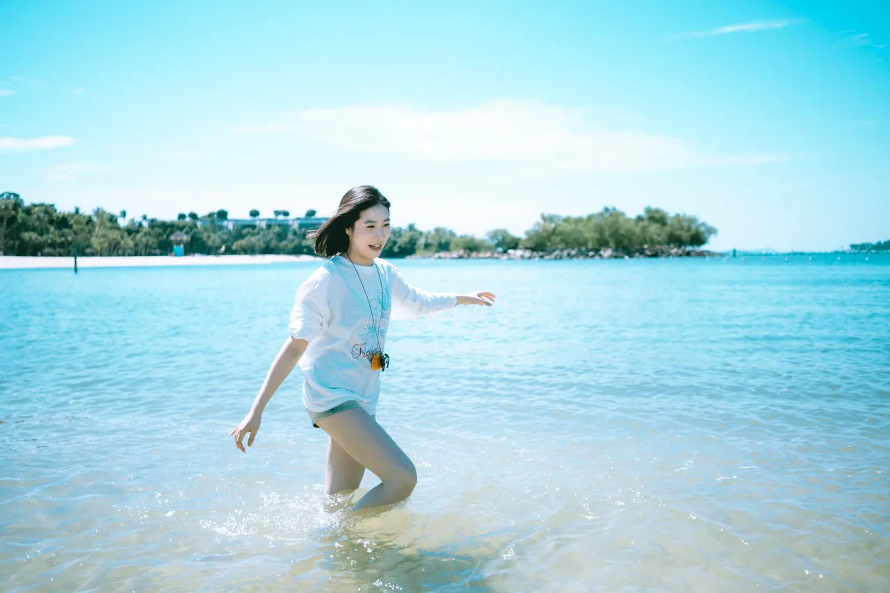 Woman wading in clear shallow water on a sunny day