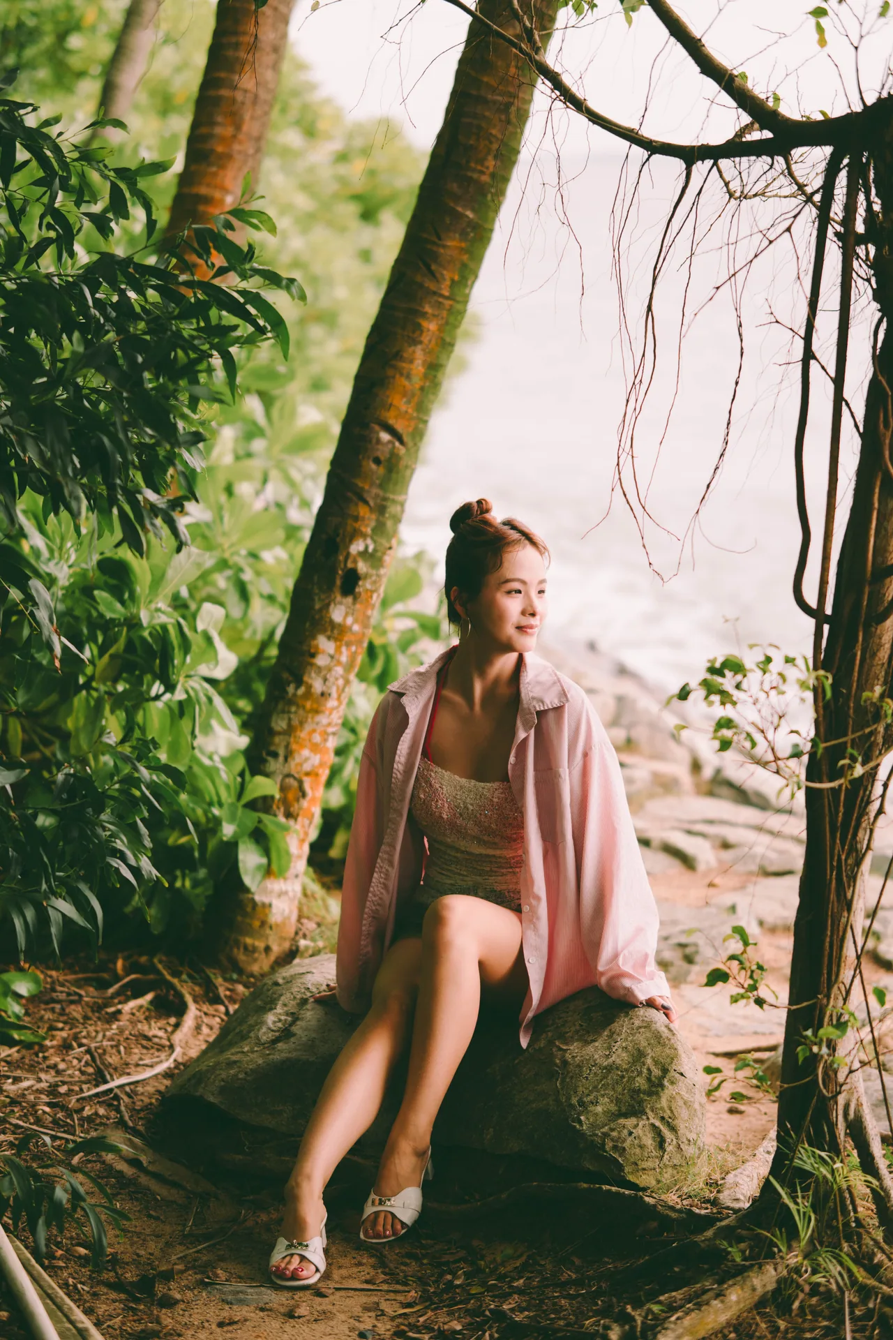 Woman sitting among tropical trees in a park