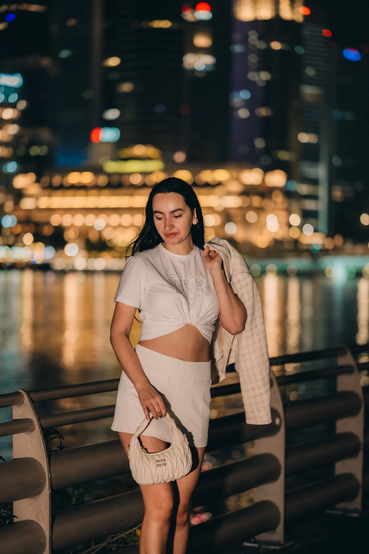 Evening portrait by the river with warm lights reflected in the water