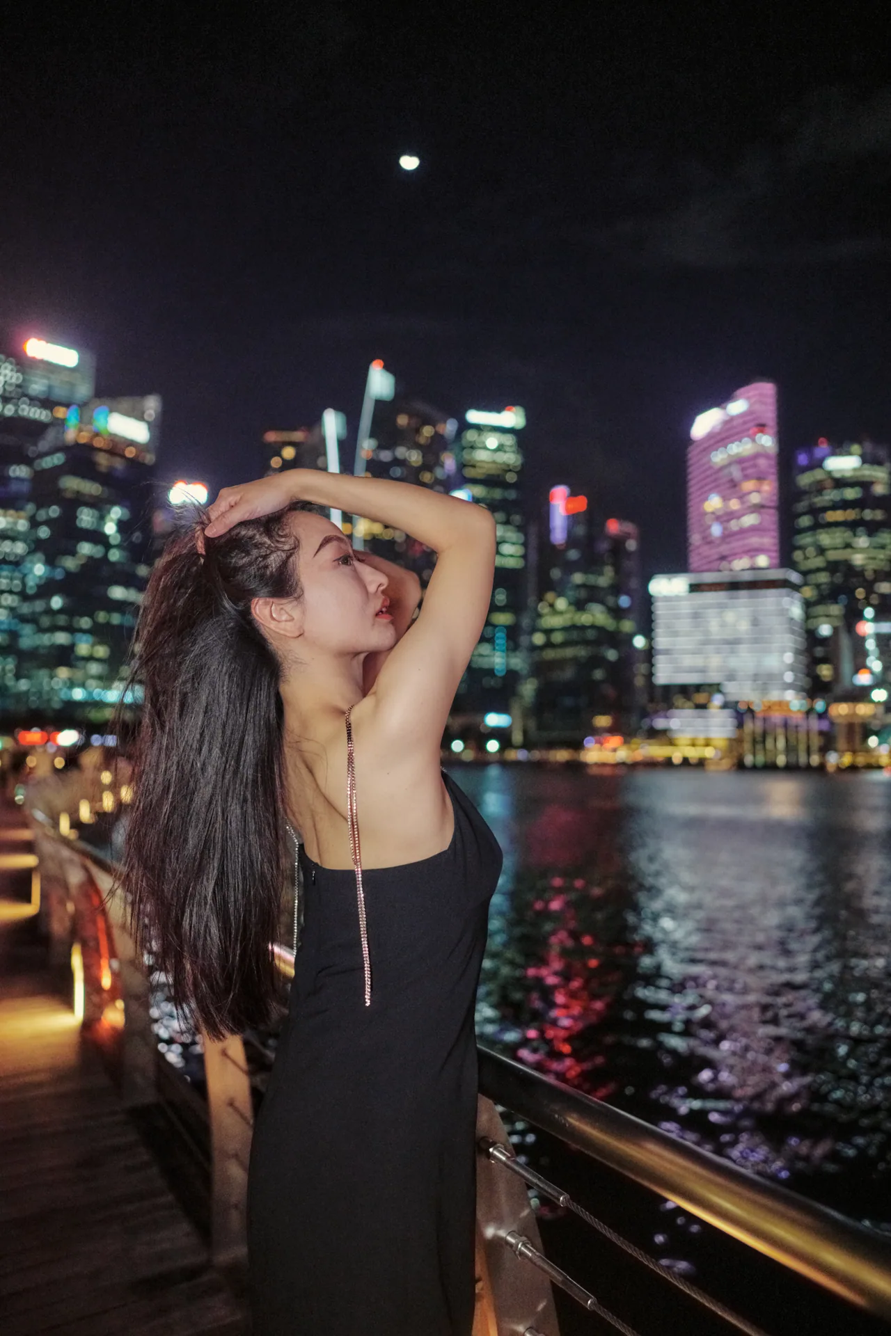 Night portrait on the Marina Bay waterfront with city lights behind